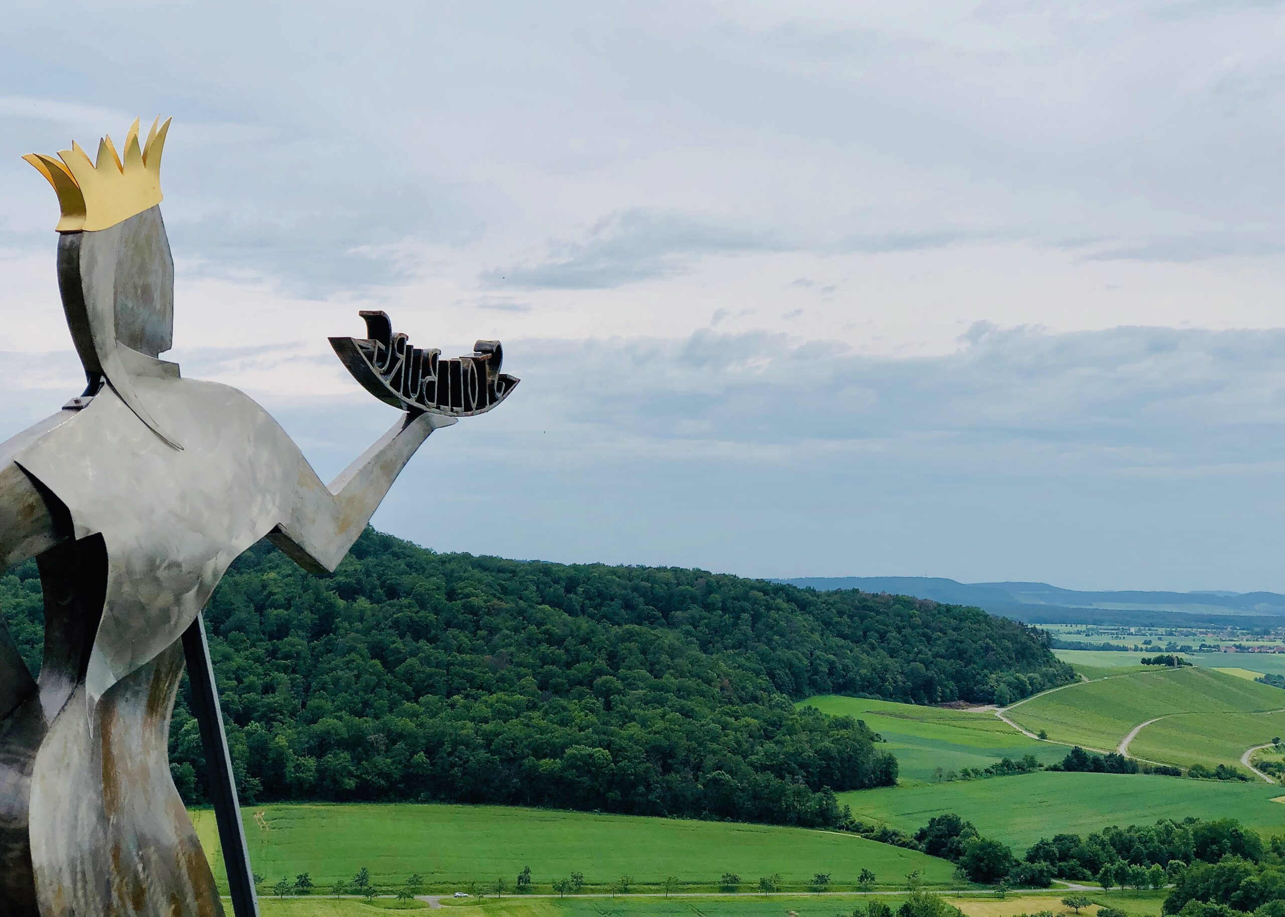 Metal statue looking onto Germany's Franken vineyards surrounded by forest.