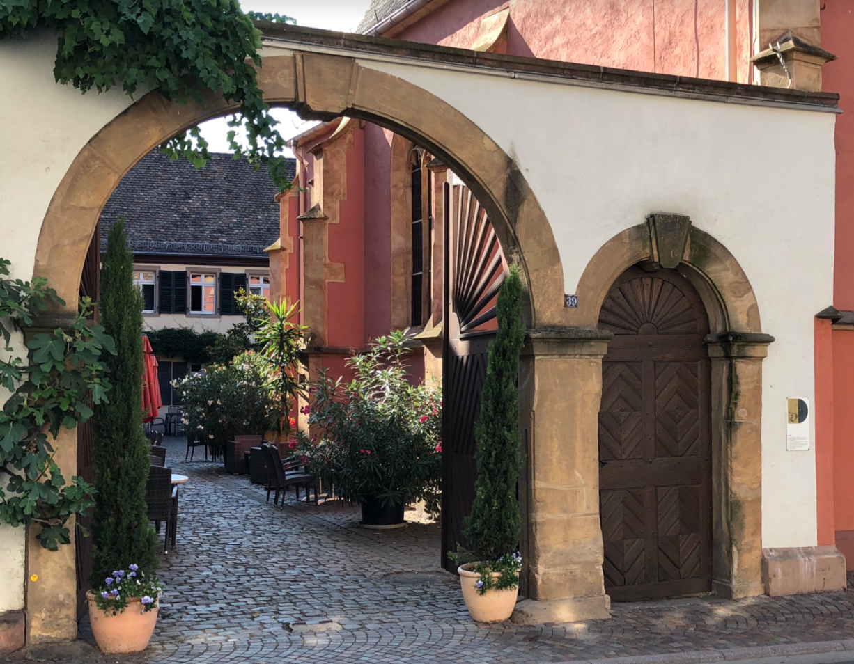Summer view of inner courtyard with plants and stone buildings in Germany's Pfalz winegrowing region