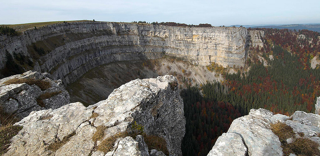 A deep, curving canyon shows striated rock layers