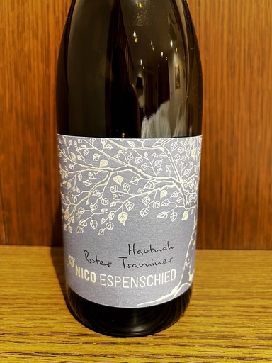 Dark glass wine bottle with grey label with a white decorative leaf patters and black and white lettering reading Hautnah Roter Traminer NICO ESPENSCHIED