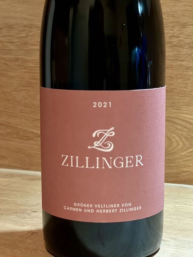 Dark glass wine bottle with mauve wine label featuring a cream-colored logo and ZILLINGER