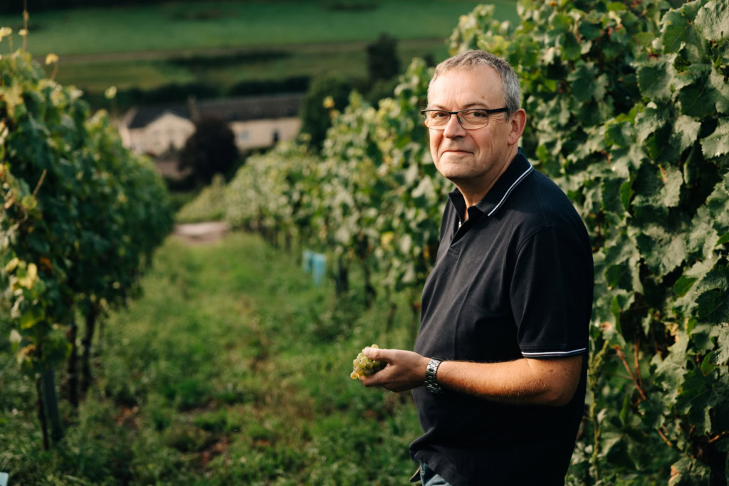Mathieu Kauffmann looks at the camera, his back to the steep sloping Karthäuserhofberg vineyard in the Ruwer