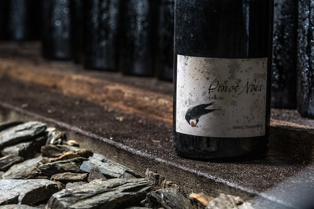 mosel pinot winebottle on a shelf next to a pile of slate rock