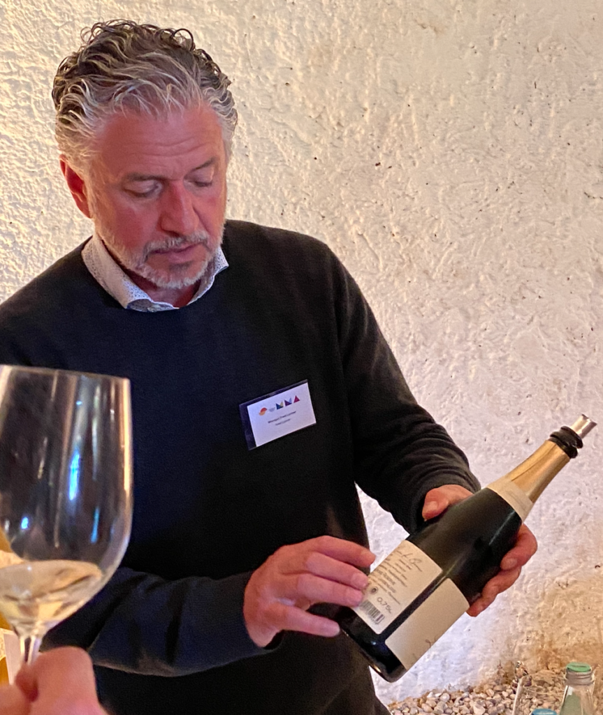 Fred Loimer shows off a bottle of his wine to a guest at Summa.