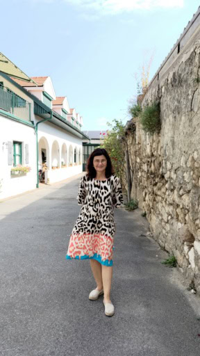 Austrian winemaker Braunstein standing in her winery hof near a stone wall