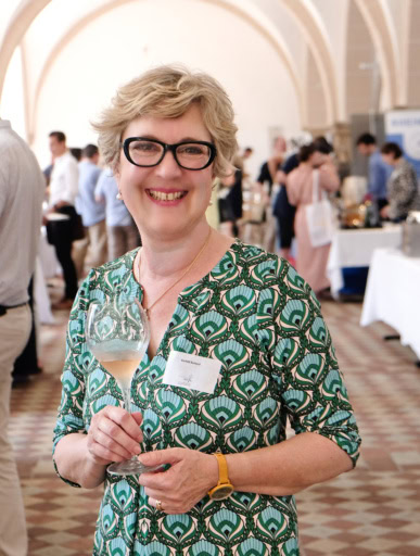 Gerhild Burkhard, Founder of International Sparkling Wine Festival, holds a glass of rose sekt in vaulted cellar