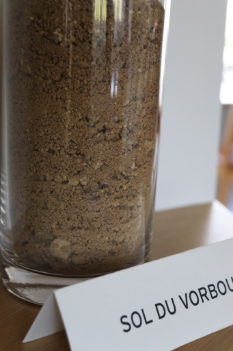 Glass jar of Alsatian vineyard soil behind a paper sign that says Sol du Vorbourg