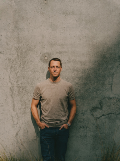 Portrait of Michael Tischler-Zimmermann, managing director of ÖTW, against a concrete wall.